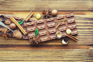 A bar of milk chocolate on the table. Chocolate with nuts and cinnamon.