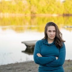 Teen girl in teal blue shirt outside in summer