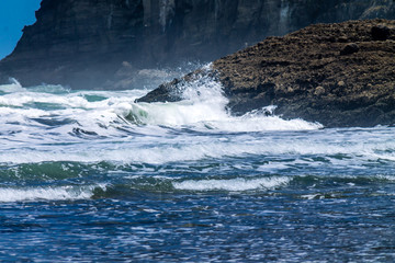 Waves crash the shore and coast line of Bethell's Beach, Auckland, New Zealand