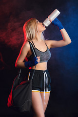 Active blonde woman in sportwear drinking a protein shaker after workout. Women only kickboxing class, fitness and skills, the perfect way to start the weekend