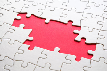 White jigsaw puzzle game pieces on red background form a banner for business theme design