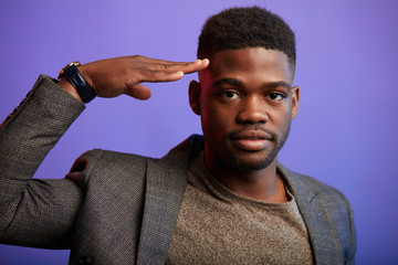Portrait of young African positive male office worker , manager assistant, in formal suit ant t-shirt , expresses positiveness, being ready to fulfil any task, eager to work.