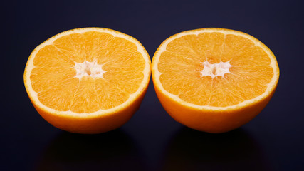 Citrus fruit. Cut orange on dark background