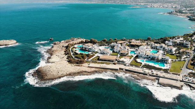 Drone Aerial of Anissaras Near Hersonissos on Famous Historic Crete Island Greece With Hotel Pools Beaches and Mediterranean Sea Turquoise Waves