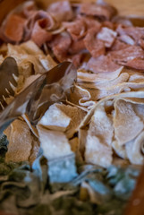 Variety of colored fresh raw uncooked homemade pasta: green spinach, pink beetroot and yellow with flour.
