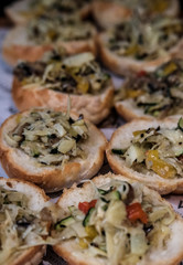 Bruschetta with mushrooms, peppers and cucumbers on wooden board. Traditional italian appetizer or snack, antipasto