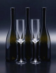 Three wine bottles and two empty wine glasses