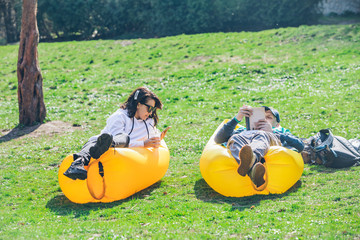 couple laying in city park on yellow inflatable mattress