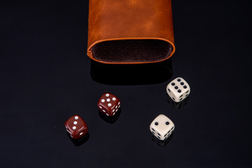 Dice with dice cup on black background