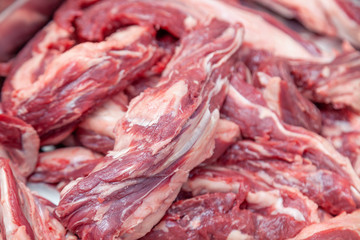 Closeup cutting fillet of fresh pieces of pork and beef meat on plastic cutting board in restaurant kitchen. Concept carve meat for grill barbeque on farmer local market