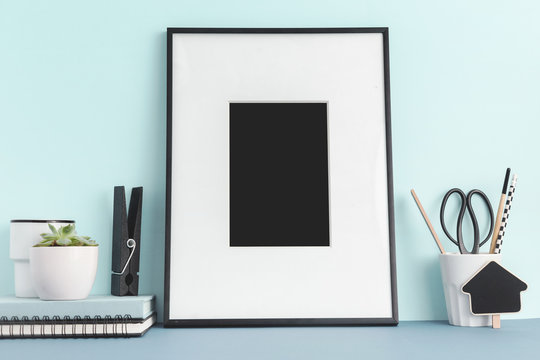 Frame on  a desk with blue wall. Mockup.