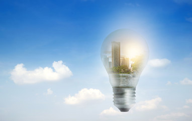 Light bulb on blue sky and city in side, technology, energy saving concept.