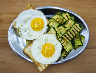 Two fried eggs with grilled zucchini and toasted bread