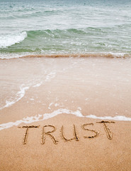 Word trust written on the sand