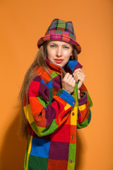 Autumn woman in hat and warm colorful clothes over bright  background