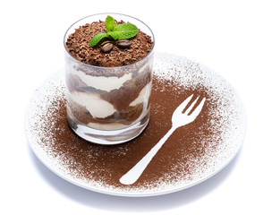 Classic tiramisu dessert in a glass on plate with fork silhouette isolated on a white with clipping path