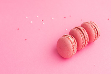Pink french macaroons on a pink background.   Minimal food bakery concept. Flat lay top view with copy space  text.