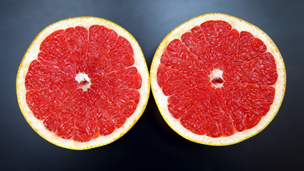 Citrus fruit. Sliced grapefruit on a dark background