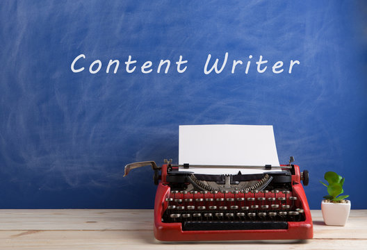 writer's workplace - red typewriter on blue blackboard background with text "content writer"