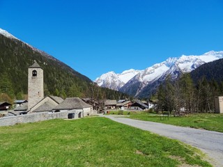Fototapeta na wymiar View of a church in the Italian Alps on a sunny day in the village of Macugnaga, Italy - April 2019