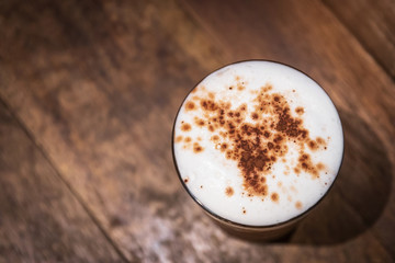 Top view of iced coffee with soft microfoam on wood table background.