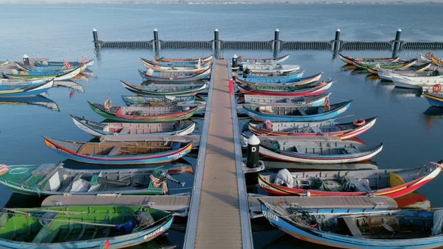 Symmetrical parked fishing boats or gondolas painted with bright colors. Concept travelling and tourism destination for urban nomads and bloggers. Marina or port in small village