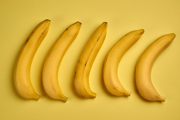 Colorful fruit pattern of fresh yellow bananas on yellow background