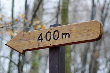 Ein Wegweiser in Form eines Pfeils als Richtungsschild aus Holz mit der Aufschrift 400m