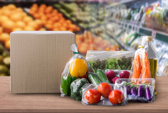 Online grocery concept. Shopping order online ingredients food for cooking and packages box with blank for text on wood table on supermarket background and food delivery service for lifestyle in city.