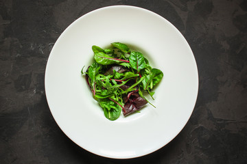 mix lettuce leaves salad in a plate (fresh green snack). food background. top