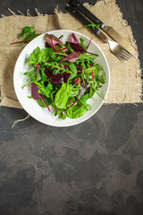 mix lettuce leaves salad in a plate (fresh green snack). food background. top
