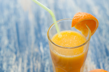 Glass of orange juice on wooden background view from the top