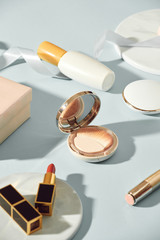 Composition with gift box and set of decorative cosmetics on blue background