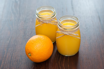 Orange juice in jars and whole fruit rustic style