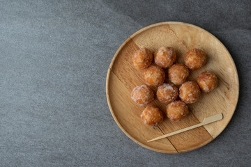 Egg swan dessert  of Thailand or Fried glutinous rice flour stuffed with palm sugar and grated coconut topping in wooden dish on concrete table.