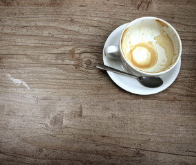 Empty capuccino cup on a grunge wooden board