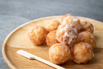 Egg swan dessert  of Thailand or Fried glutinous rice flour stuffed with palm sugar and grated coconut topping in wooden dish on concrete table.