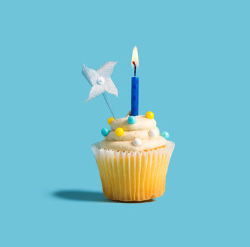 Celebratory cupcake with a decorative lit candle