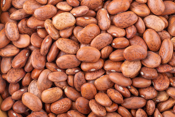 pinto beans in a wooden bowl isolated on a white background