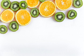 Kiwi and orange slices on white wooden background. Fresh and natkralnye vitamins. Healthy food. Flat lay, top view.