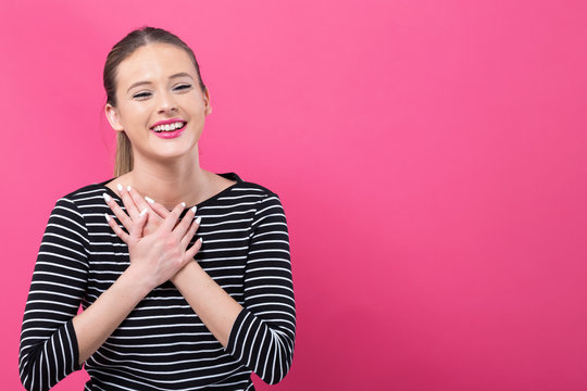 Woman With Heartfelt Expression On A Pink Background