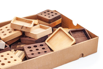 Assortment of wood handcraft pieces in carton box on white background