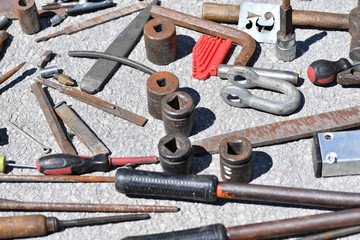 Old and rusty tools on an asphalt background on a market in Spain.