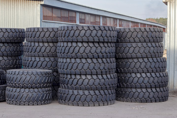 Large rubber tires for trucks lying on the street. Black tires close-up with large tread.