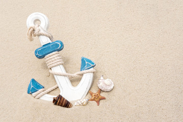 Fototapeta na wymiar Nautical background with anchor. Anchor in the sand. Frame for a banner text from sand with an anchor and seashells