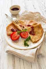 Pancakes with fresh strawberries and jam close up