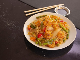 Shrimps with Rice and Vegetables Cantonese Style on a White Plate with Soy Sauce 