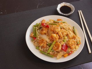 Shrimps with Rice and Vegetables Cantonese Style on a White Plate with Soy Sauce 
