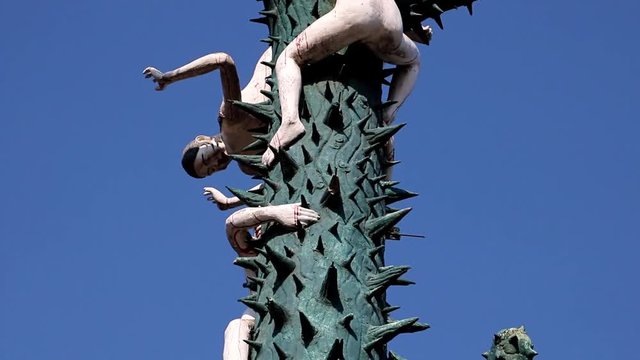 SUPHAN BURI, THAILAND, JAN 01 2018, Naked sinners climb on a thorny tree with sharp spikes. A scene from Buddhist hell. Torture of sinful people, afterlife.