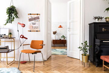 Stylish compositon of retro home interior with mock up poster frame, vintage orange chair, piano,furnitures, design lamps, gold shelf, plants and elegant accessories. Nice home decor of living rooms. 